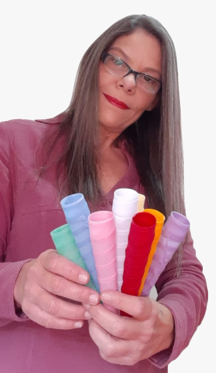 Susi Kelly segurando em suas mãos os cones brancos e coloridos utilizados em limpeza energética